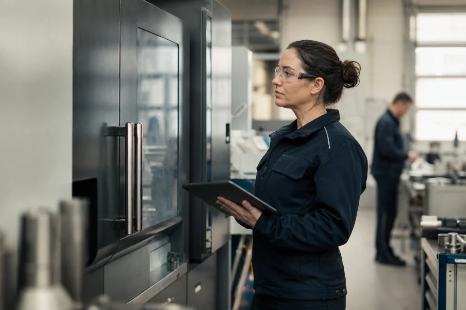 Eine Fachkraft mit Schutzbrille kontrolliert eine geschlossene Industrieanlage.